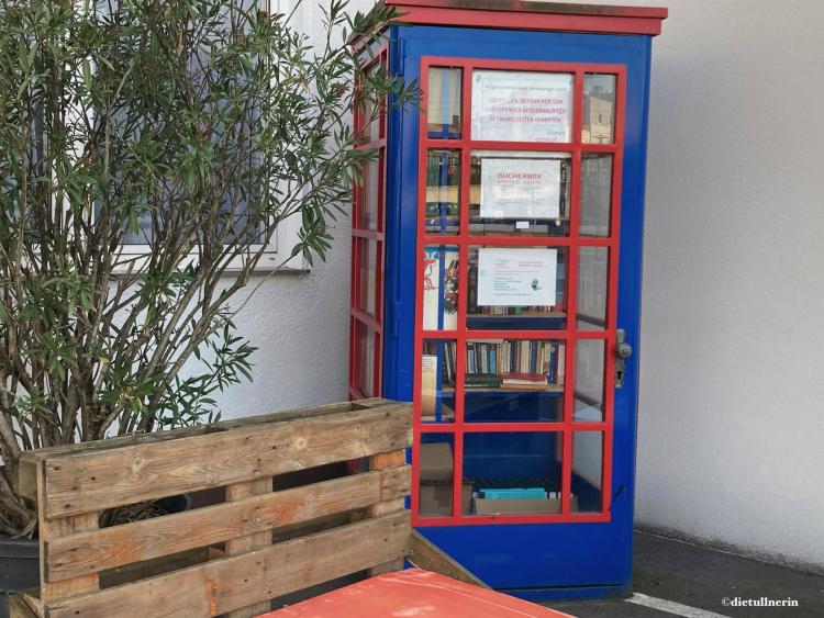 ausrangierte Telefonzelle in bunten Farben zum offenen Bücherschrank umfunktioniert. Standort: Soo gut Markt in Tulln
