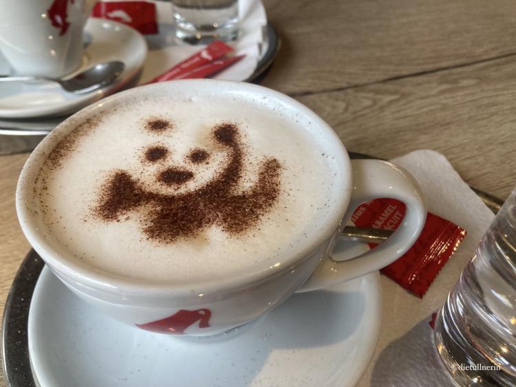 Cappuccino mit Kakao-Topping im Panda-Look 