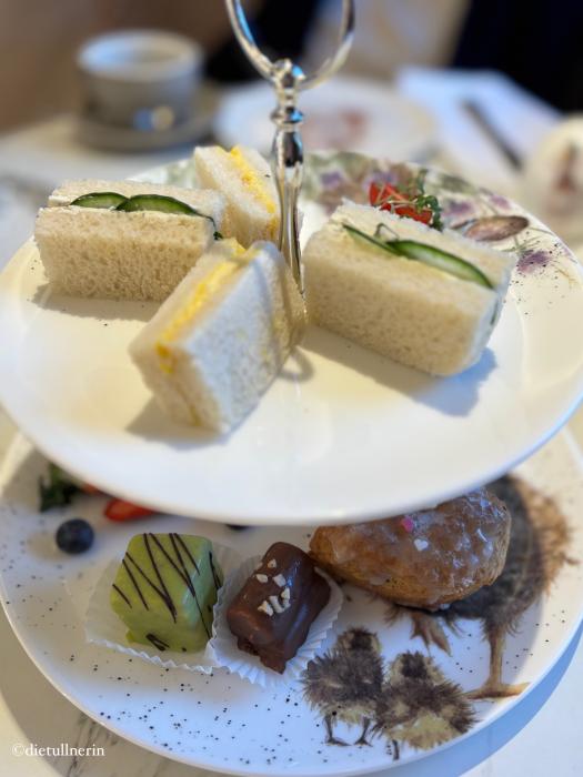 Etagere mit Mini-Sandwiches, kleinen Mehlspeis-Häppchen und Scones